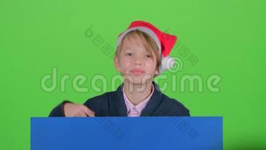 小男孩从蓝色海报后面出现，指向他的食指。 绿色屏幕